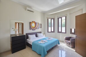 A bedroom with a bed, dresser, and a large window.
