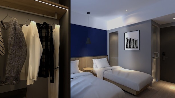 A modern hotel room with two beds, a wardrobe, and a wall-mounted artwork. - LeGreen Suite Sudirman (Jakarta)