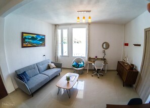 Cozy living space with a sofa, coffee table, desk, and office chair.