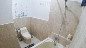 A bathroom with a bathtub, toilet, and shower. - San Pedro Suite (San pedro la Laguna solola)