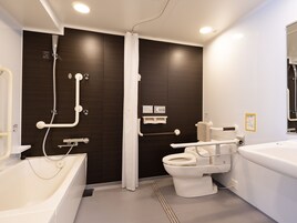 Un baño moderno con bañera, inodoro y zona de ducha.