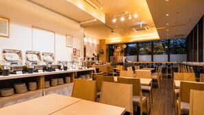 Un intérieur de restaurant moderne avec un espace buffet, plusieurs tables et chaises.