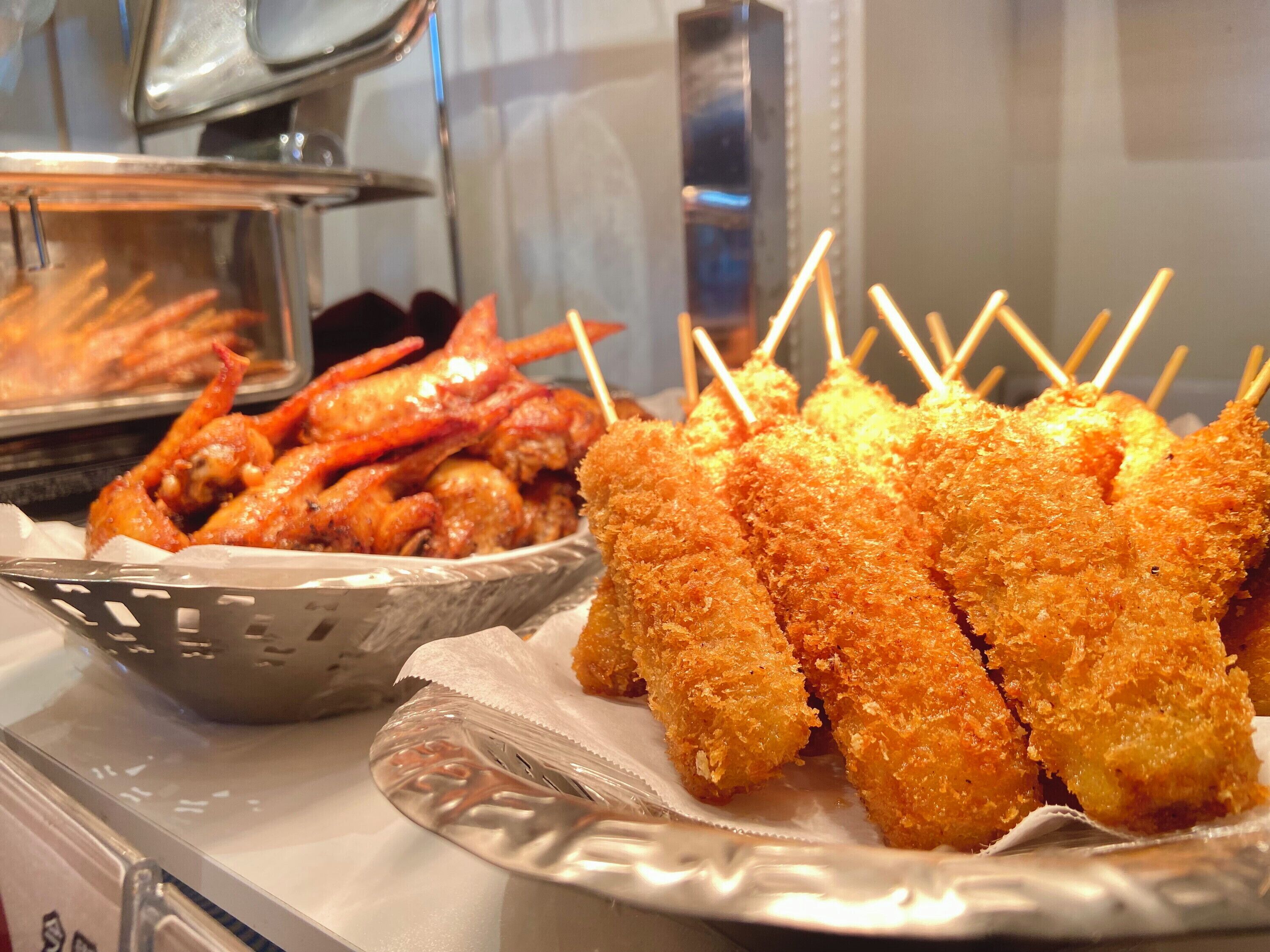 A buffet with fried shrimp and breaded chicken skewers.