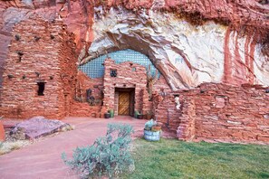 A historic building with a large arched doorway, stone walls, and a small wooden door. - Modern/Luxury Townhouse- HOT TUB - Sleep up to 8! (Kanab)