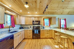 A kitchen with wooden cabinets, a microwave, a stove, and a sink. - 'Adirondack Dream' Your Lakefront Escape (Black Brook)