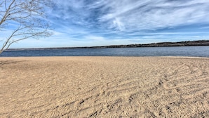 A sandy beach with a clear sky and a tree on the left. - Lakeland Cottage - 1/2 Mile to St Croix River (Lakeland)
