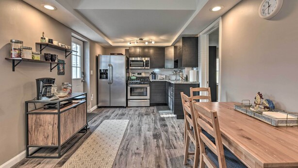 A modern kitchen with a built-in oven, microwave, and refrigerator. There is a dining table with chairs and a coffee machine on a wooden console table. - Lakeland Cottage - 1/2 Mile to St Croix River (Lakeland)