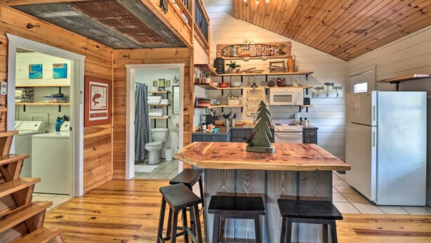 A spacious kitchen with wooden accents, a central island, bar stools, and a high ceiling with exposed beams. - Cheery Pet-Friendly Studio w/ Shared Fire Pit (Mountain View)