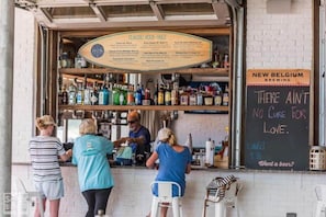 A bar with a menu board listing classic rock songs and a chalkboard sign with a love-themed message. - Charming 30A Getaway, Bikes, Steps to Pool, Near Beach ~ Pearl Lighthouse 30A (Inlet Beach)
