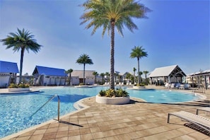 A pool area with palm trees, lounge chairs, and a clear blue sky. - Charming 30A Getaway, Bikes, Steps to Pool, Near Beach ~ Pearl Lighthouse 30A (Inlet Beach)