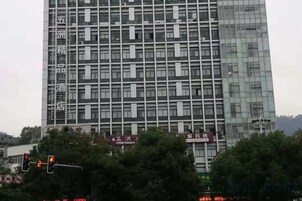 Un edificio de varios pisos con una cuadrícula de ventanas y un letrero con caracteres chinos.