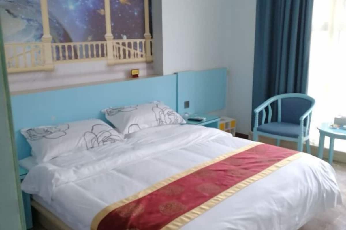 Een hotelkamer met een bed, een nachtkastje, een stoel en een kleine tafel.