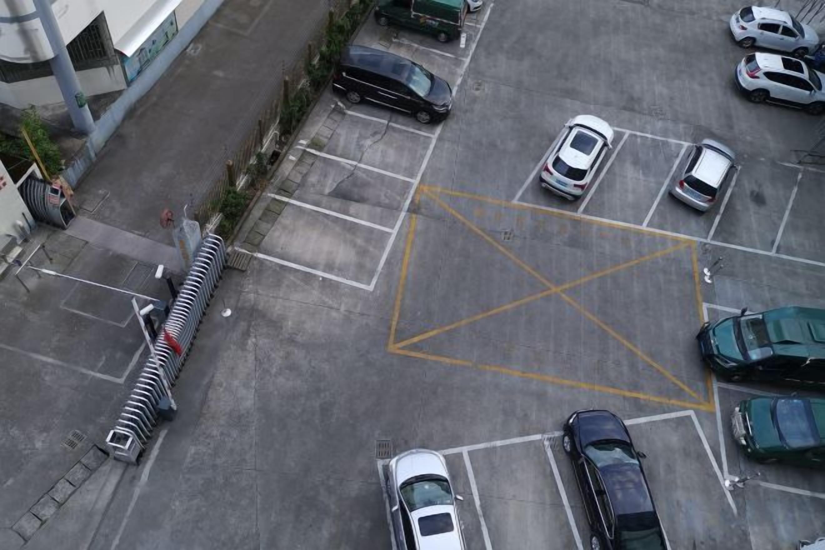 Vista aérea de un estacionamiento con varios automóviles y una pasarela para peatones.