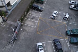 An aerial view of a parking lot with multiple cars and a pedestrian walkway. - Wuzhou Boutique Hotel (Sanmen)
