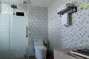 A bathroom with a toilet, a glass shower enclosure, and a towel rack.