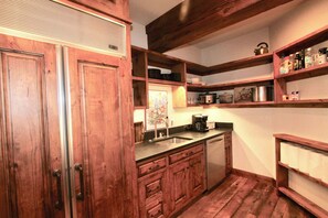 A kitchen with wooden cabinets, a sink, and a stove.