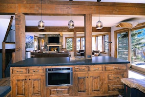 A kitchen with wooden cabinets, a built-in oven, and hanging pendant lights.