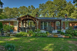 A house with a covered patio, brick exterior, and a well-maintained garden. - Charming Florence Getaway w/ Fireplace & Grill! (Florence)