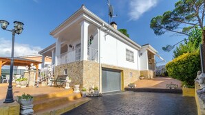 Una casa de dos pisos con fachada de piedra, un balcón y un garaje.