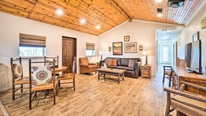 A spacious living room with a high wooden ceiling, a fireplace, a sofa, and a television. - Relaxing Rural Harrison Home - 11 Mi to Town (Harrison)