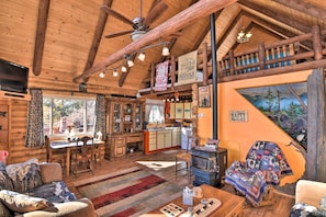 Interior acogedor de una cabaña de madera con comedor, cocina y sala de estar.