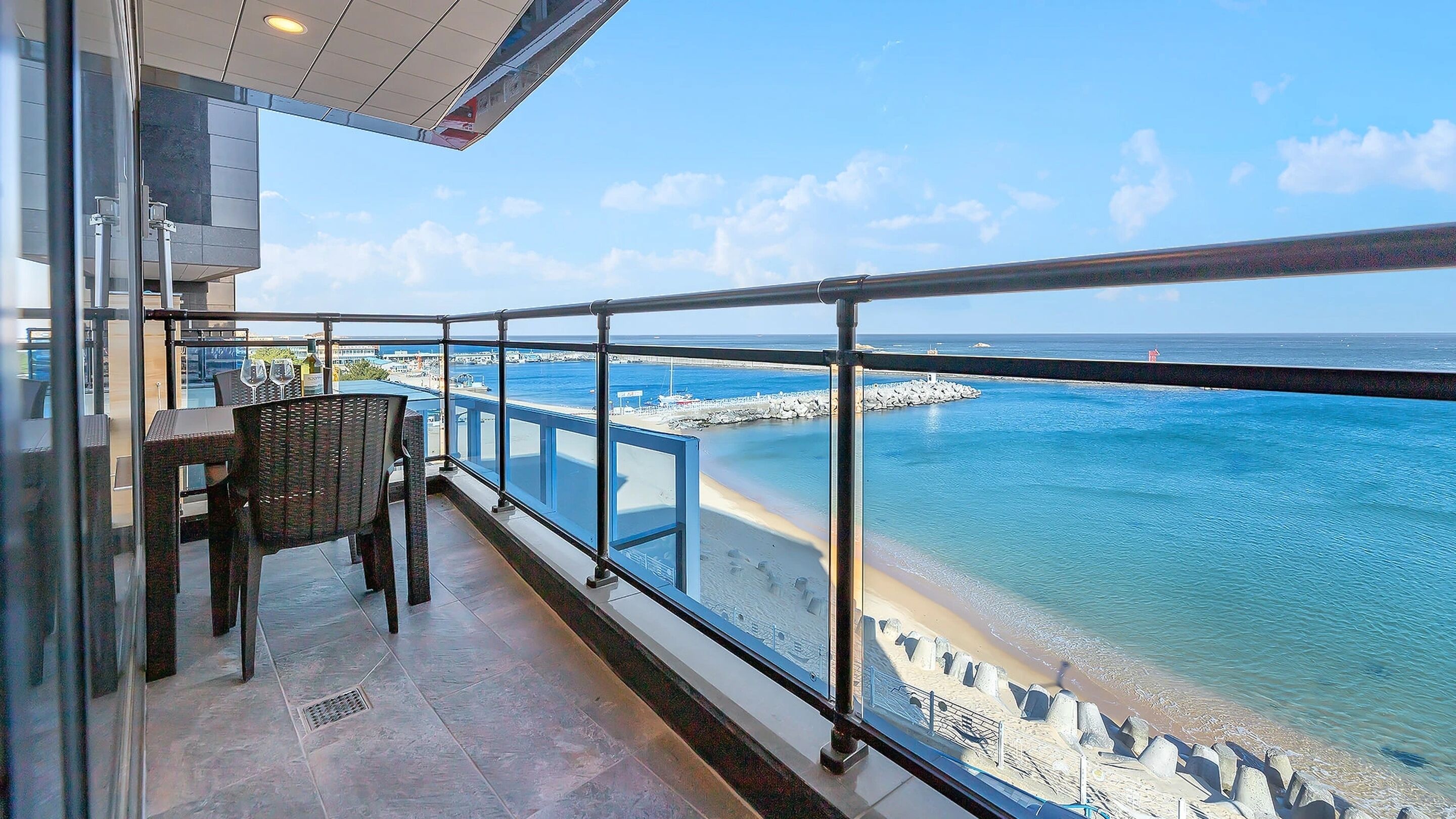 A balcony with a view of a beach and the ocean.