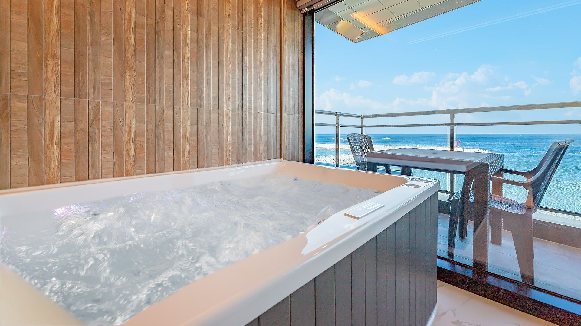 A hot tub on a balcony with a view of the ocean.