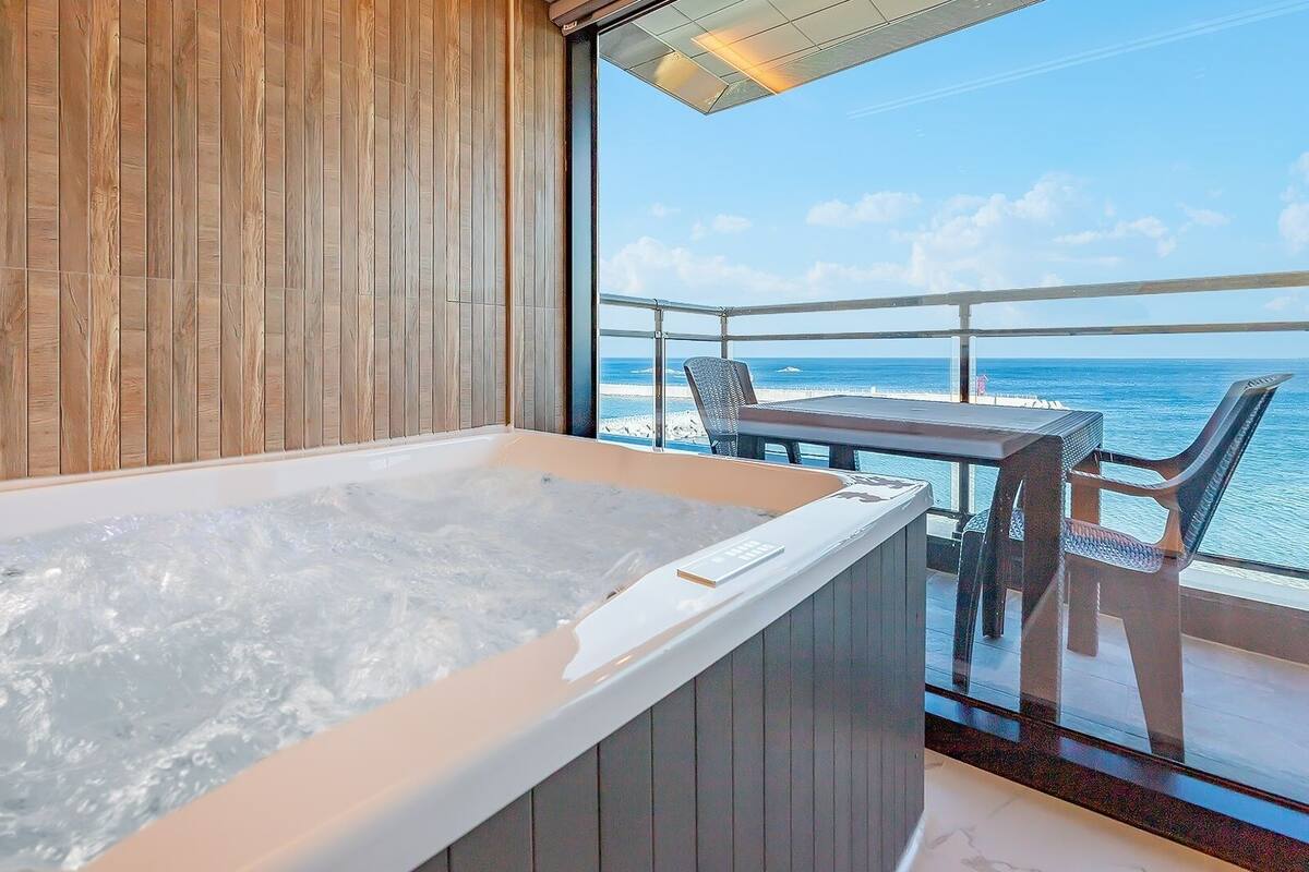 Un jacuzzi en un balcón con vista al océano.