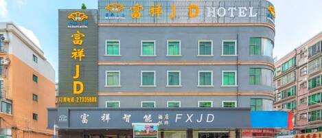 A hotel with a modern facade, multiple floors, and a prominent sign.