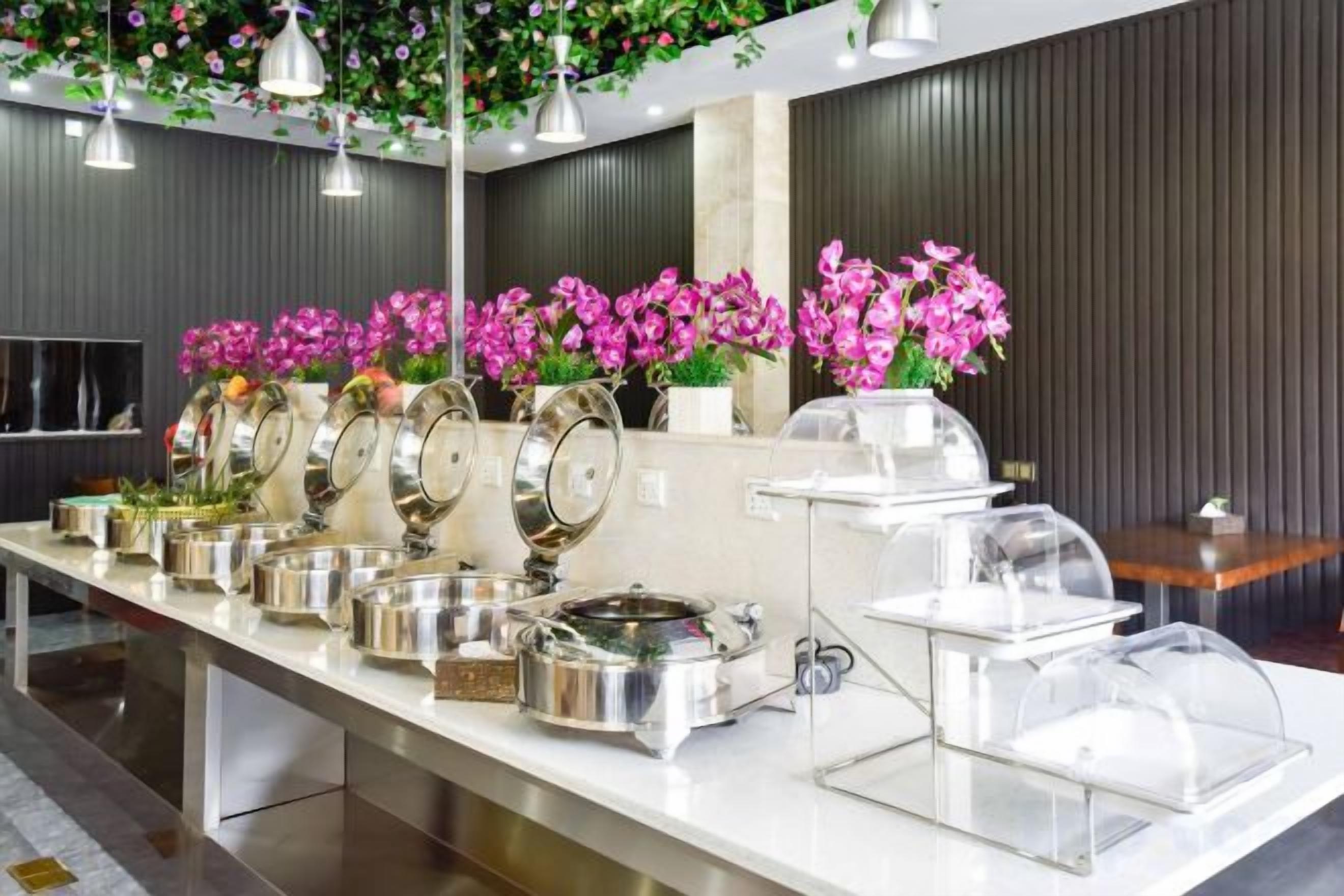 Ein reichhaltiges Buffet mit verschiedenen Speisebehältern und einer Blumenkomposition.