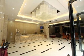 A hotel lobby with a marble reception desk, a large chandelier, and a modern floor design. - Fuxiang Hotel (Foshan Shunde Lunjiao Branch) (Foshan)