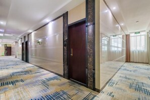 A hotel corridor with carpeted flooring, doors, and a ceiling with recessed lighting. - Fuxiang Hotel (Foshan Shunde Lunjiao Branch) (Foshan)