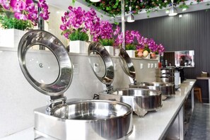 A buffet setup with stainless steel serving dishes and a counter. - Fuxiang Hotel (Foshan Shunde Lunjiao Branch) (Foshan)
