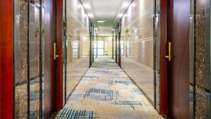 A long, narrow hallway with marble walls and doors, leading to a bright room at the end. - Fuxiang Hotel (Foshan Shunde Lunjiao Branch) (Foshan)