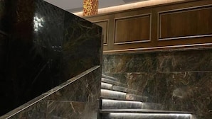 A marble staircase with a dark finish, leading to a wooden panel wall. - Richun Teaism Hotel (Quanzhou)
