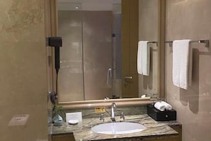 A modern bathroom with a marble sink, a large mirror, and a towel rack. - Richun Teaism Hotel (Quanzhou)