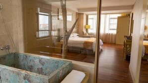 A hotel room with a large bathtub, a bed, a desk, and a window. - Richun Teaism Hotel (Quanzhou)