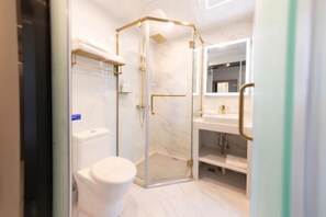 A modern bathroom with a glass-enclosed shower, a toilet, and a vanity with a mirror. - Guangzhou Xiguan Yuehua Hotel (Guangzhou)