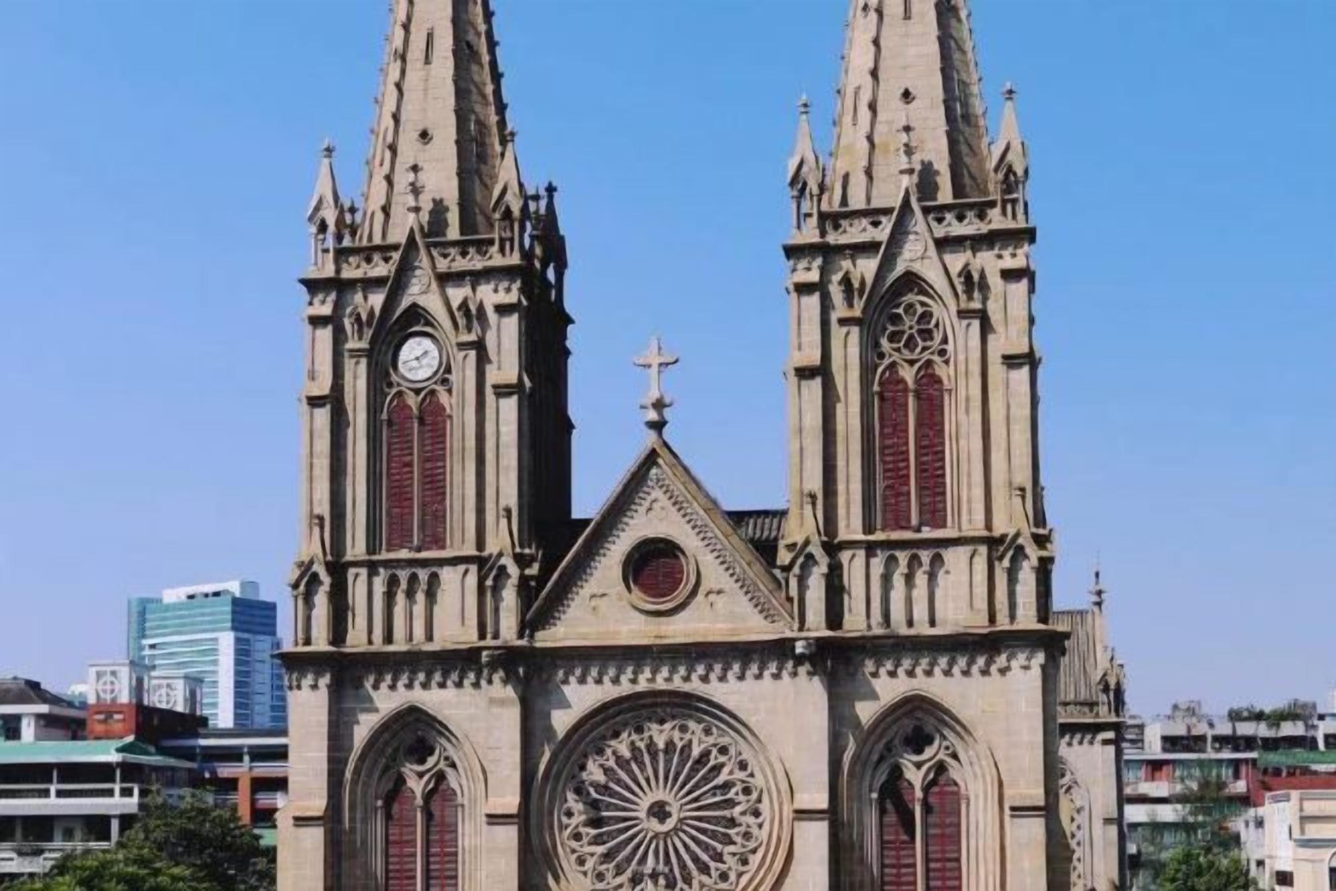 Une grande église dotée de deux hautes flèches, d’une rosace centrale et d’une horloge.