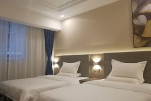 A hotel room with two beds, a large window with curtains, wall-mounted lights, and a painting.
