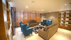 Una sala de estar moderna con un sofá, dos sillones y una mesa de centro.