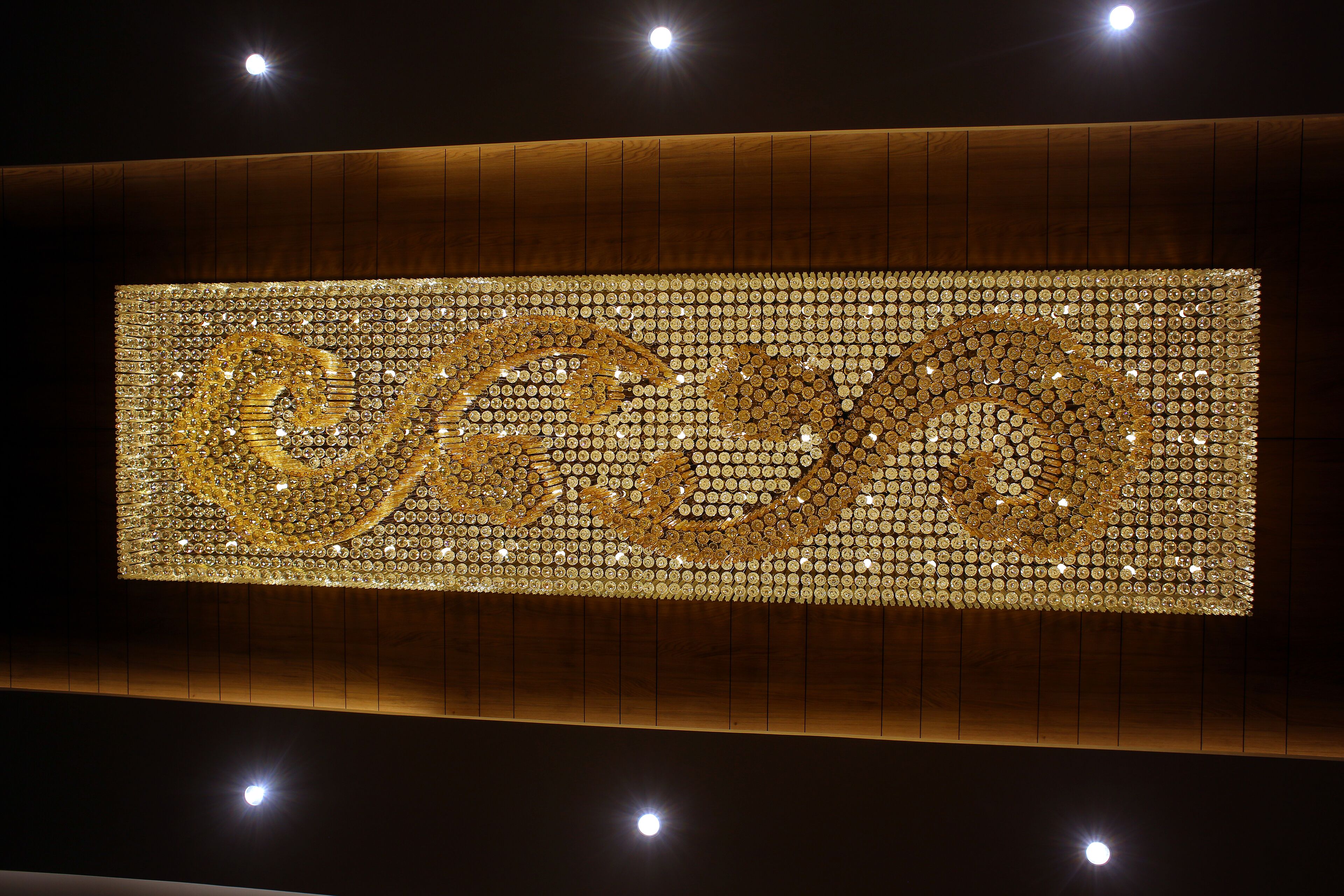 Uma grande parede iluminada com um desenho circular dourado.