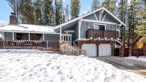 A two-story house with a balcony, a garage, and a snow-covered driveway.