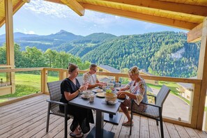 A wooden deck with a table and chairs overlooking a mountainous landscape. - Modern Mountain Stay (Abondance)