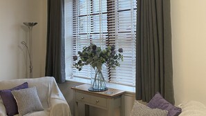 A room with two sofas, a desk, and a window with blinds. - The Howff - Lovely 2-bed Apartment in Anstruther (Anstruther)