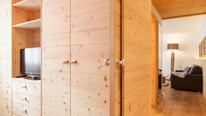 A wooden wardrobe with a television on top, a sofa, and a lamp in a living area. - Agriturismo Sittnerhof - a place to stay for those seeking relaxation in Meran e (Meran)