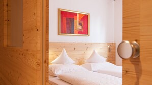 A wooden-paneled room with a bed featuring two pillows and a framed artwork on the wall. - Agriturismo Sittnerhof - a place to stay for those seeking relaxation in Meran e (Meran)