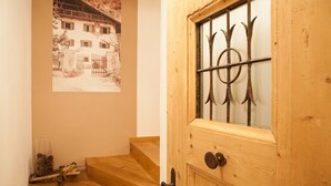 A wooden staircase leading to a door with a metal grille. A vintage photograph is displayed on the wall above the stairs. - Agriturismo Sittnerhof - a place to stay for those seeking relaxation in Meran e (Meran)