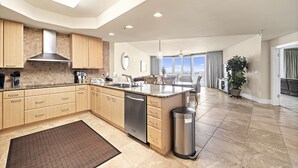 A spacious kitchen with a large island, built-in appliances, and a view to the living area.