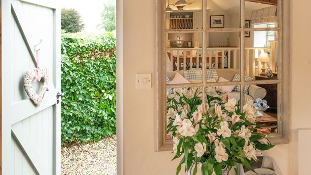A room with a white door, a window with multiple panes, and a view of a garden. - The Stables -  A rural, romantic retreat in a particularly pretty countryside setting close to Castl (Great Maplestead)